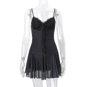 Close-up of black polka dot mesh dress featuring lace trim and front tie detail.