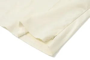 Detailed macro view showing the side hidden zipper and hem stitching of the cream bandeau top