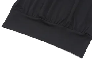 Close-up view of black off-the-shoulder crop top with a pleated elasticated hemline