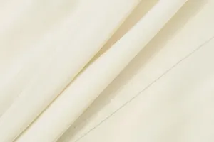 Macro detail of high-quality white fabric with fine stitching and smooth texture.