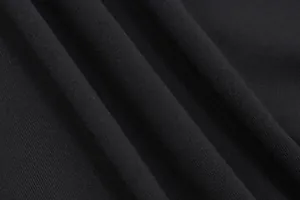Professional macro shot of soft black knit fabric texture showing fine weave patterns