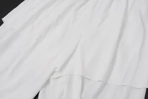 Primer plano de tela blanca texturizada con detalles de costuras y capas finas.