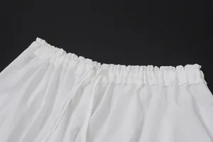 Detalle de pantalones blancos con cintura elástica con volantes y cordón ajustable