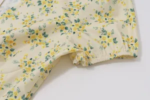 Detailed view of the puff sleeve and floral pattern on a yellow vintage summer dress
