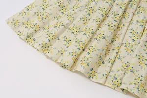 Detailed macro view of French vintage floral dress hem with delicate pleats and patterns