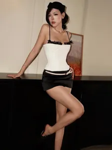 Elegant white corset top with black lace trim and spaghetti straps for summer fashion