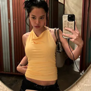 Detailed view of a yellow slim-fit halter neck backless vest top on an Asian model