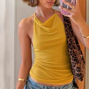 Detail shot of a yellow halter neck open back slim fit top showing the cowl neck drape