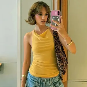 Chic yellow halter neck top with sexy backless design worn by model in mirror selfie