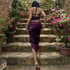 Elegante set da vacanza in raso viola con pizzo delicato in una suggestiva cornice di giardino.
