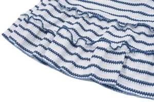 Close-up detail of blue and white striped fabric with tiered ruffle design on dress