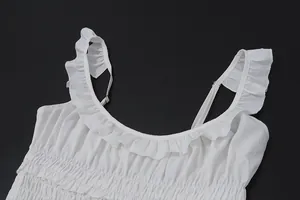 Primer plano de un vestido blanco de verano con escote de volantes y nido de abeja