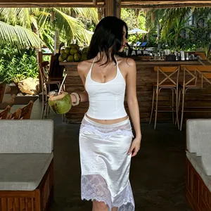 Elegante completo bianco con top a scollo all'americana e gonna in pizzo irregolare da resort