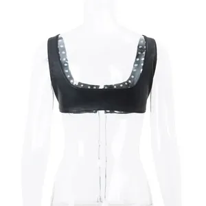 Detail showing black faux leather cropped top with stylish polka dot interior lining.