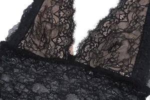Dettaglio ravvicinato del pizzo floreale nero e dei bordi sfrangiati su un top sexy trasparente