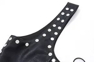 Close-up detail of silver studs on a black textured faux leather vest strap