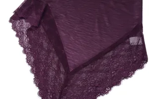 Dettaglio ravvicinato del lussuoso tessuto di raso viola con bordo in pizzo floreale unico