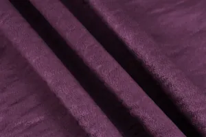 Primo piano di pregiato tessuto strutturato viola scuro con drappeggio elegante.