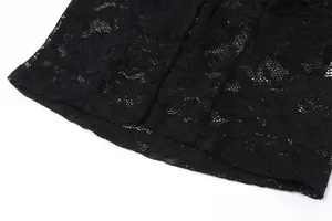 Close-up of black lace fabric with intricate floral patterns and fine stitching detail.