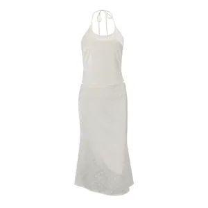 Elegant white halter neck top and midi skirt set featuring subtle polka dot texture