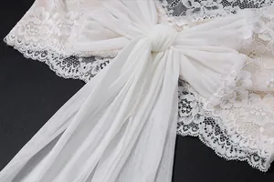 Primo piano dell'elegante fiocco in pizzo bianco e mesh trasparente su un top corto