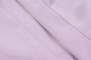 Detailaufnahme von helllila Stoff mit feiner Textur und glatten, präzisen Nähten