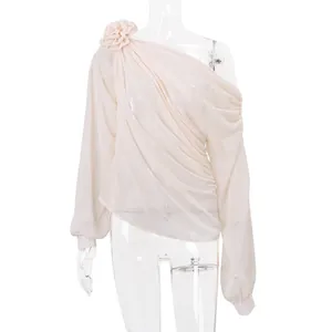 Nahaufnahme des beigen One-Shoulder-Netzoberteils mit floraler Applikation und Drapierung