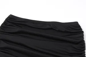 Macro view showing the elegant ruched texture and elastic waistband of a black mini skirt