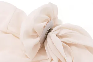 Detailansicht einer großen Chiffon-Blumendekoration an einem schulterfreien Oberteil.