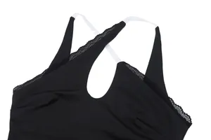 Close-up of black bodysuit with lace trim, clear cross straps and front cutout detail.