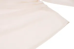 Nahaufnahme von cremefarbenem Chiffonstoff mit eleganter Plissee-Textur und weichem Netz.