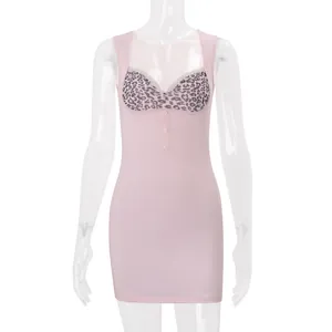 Vista dettagliata del mini abito rosa aderente con busto leopardato e bottoni frontali.