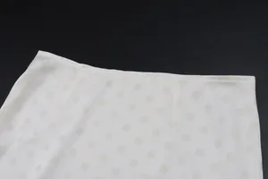 Close-up of white polka dot skirt waistband showing fabric texture and stitching detail.