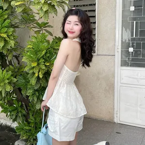 Modella con sexy completo bianco in pizzo con top a fascia schiena scoperta e shorts