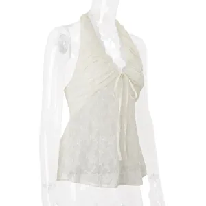 Dettaglio di un top a fascia in pizzo bianco con scollo a V e lacci per l'abbigliamento.