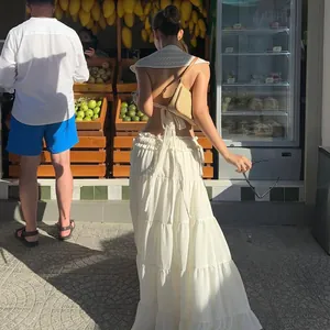 Back view of white lace-up hollow out top with flutter sleeves in a summer market setting