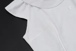 Detalle de una blusa blanca sin mangas con mangas de volante y costuras precisas