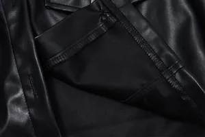 Gros plan sur la texture et les coutures de la veste en similicuir noir.