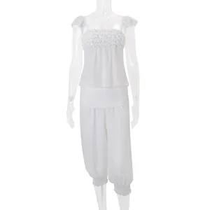 Vooraanzicht van de witte tweedelige set met ruches top en trendy harembroek