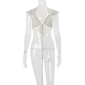 Detailed front view of white crochet lace tie-front top with shell decorations on mannequin