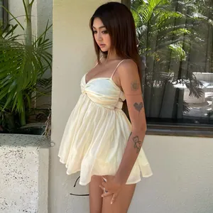 Side view detail of a light yellow chiffon babydoll top with spaghetti straps