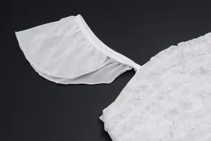 Detailopname van witte mesh vlindermouw met elegante ruches en delicate plooien