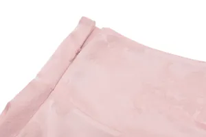Nahaufnahme des versteckten Seitenreißverschlusses am rosa Jacquard-Minirock aus Stoff