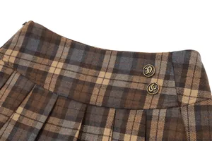 Macro view of retro plaid pleated skirt waistband featuring ornate vintage gold buttons