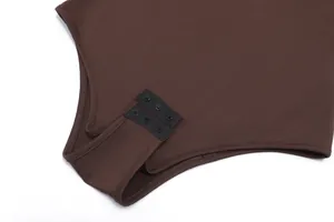 Close-up detail of a sleek brown bodysuit featuring a triple snap button crotch closure