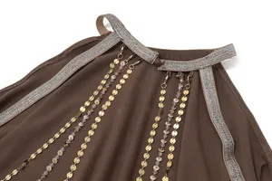 Detail view of brown dress neckline with sparkling trim and golden disc chain fringe