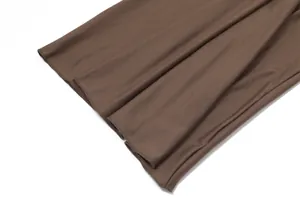 Close-up detail of brown backless dress hemline showing high-quality stitching and fabric texture