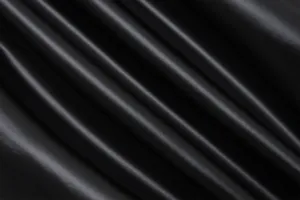 Close-up macro texture of high-quality black PU faux leather fabric with subtle sheen