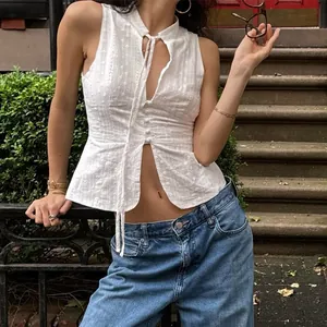 Detailed view of a stylish white eyelet lace sleeveless tie-front crop top for summer.