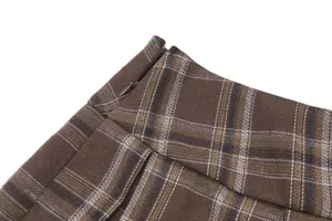 Primer plano de la cremallera invisible lateral de una falda plisada a cuadros marrón